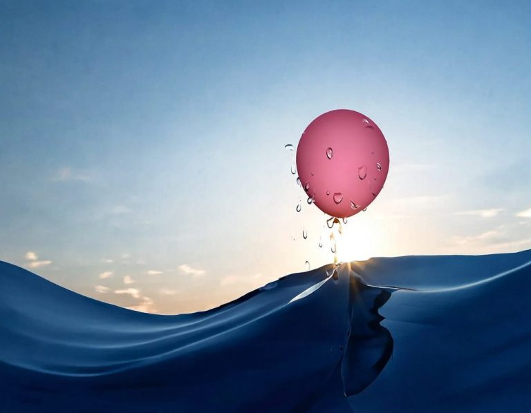 Angelika Stux - Mit Leichtigkeit weitergehen Ein rosa Ballon ist gerade einer sanften Welle entstiegen, schwebt erleichtert, sonnenbeleuchtet über dem Wasser, Wassertropfen perlen ab.
